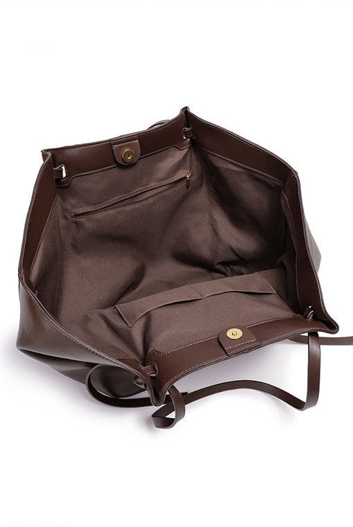 Chocolate brown leather tote bag open showing inner pockets, top-down view