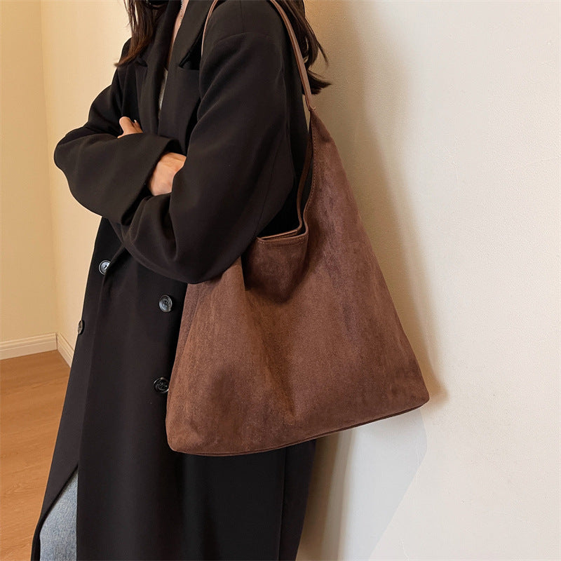 Model wearing the coffee brown suede tote bag over her shoulder