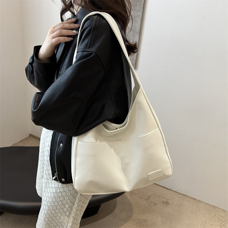 Ivory white leather slouchy shoulder bag worn on model, close-up
