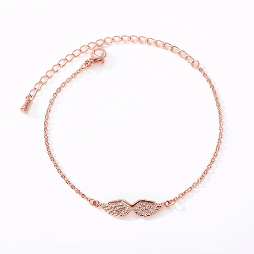 Rose gold angel wing bracelet, flat lay close-up