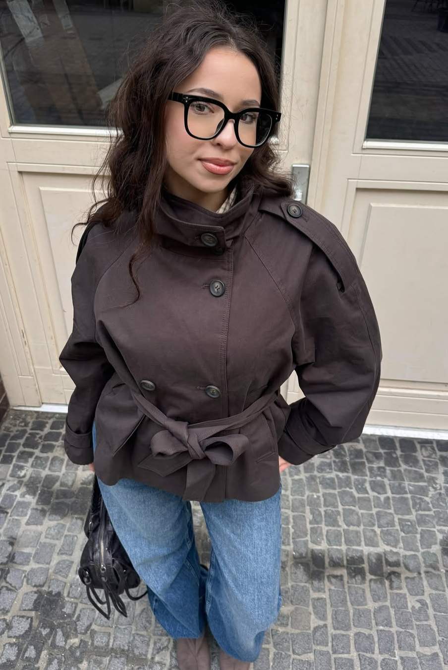 Brown short trench coat with funnel collar, close front view on model
