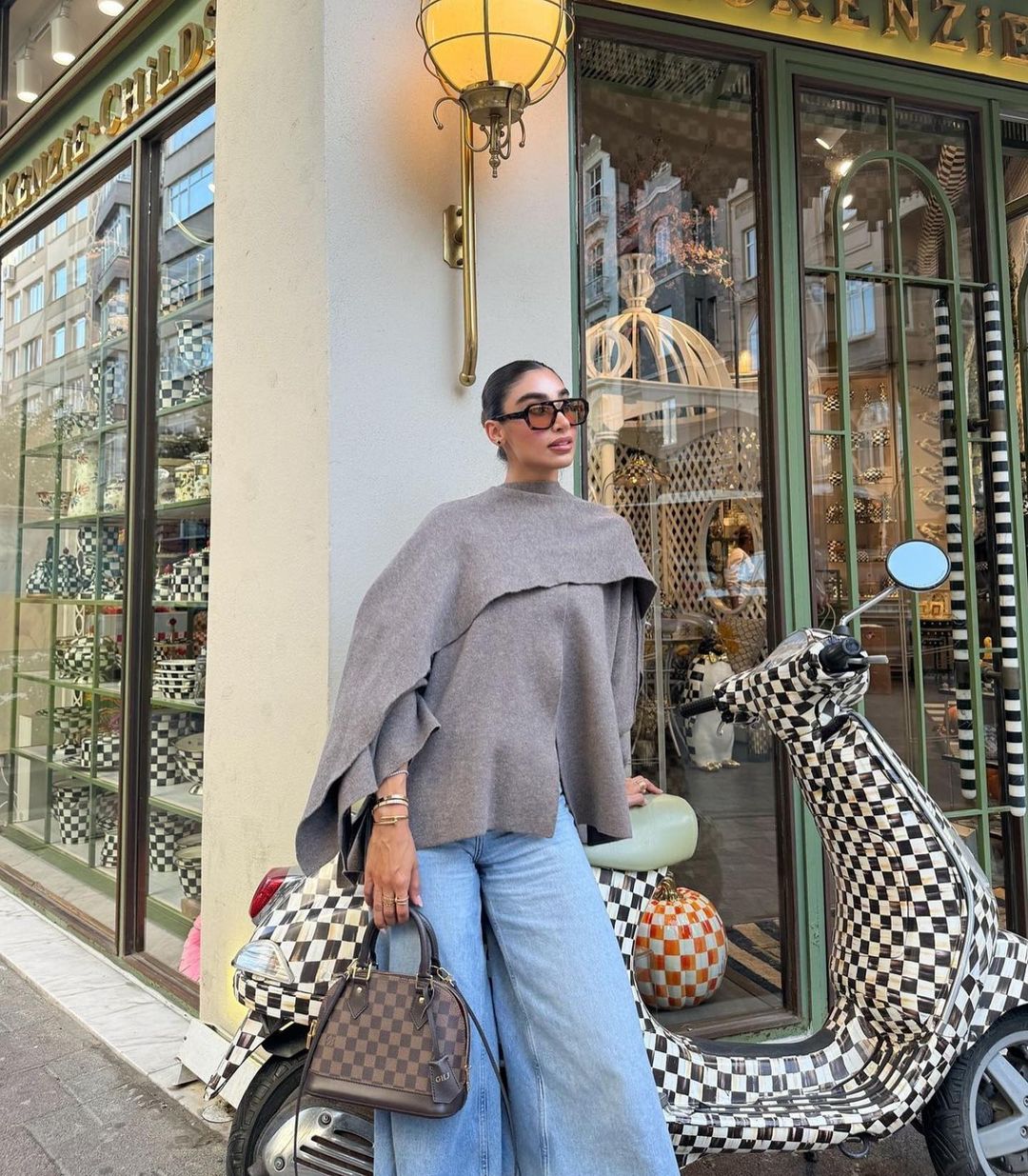 Taupe short cape styled with jeans, front view on model outdoors
