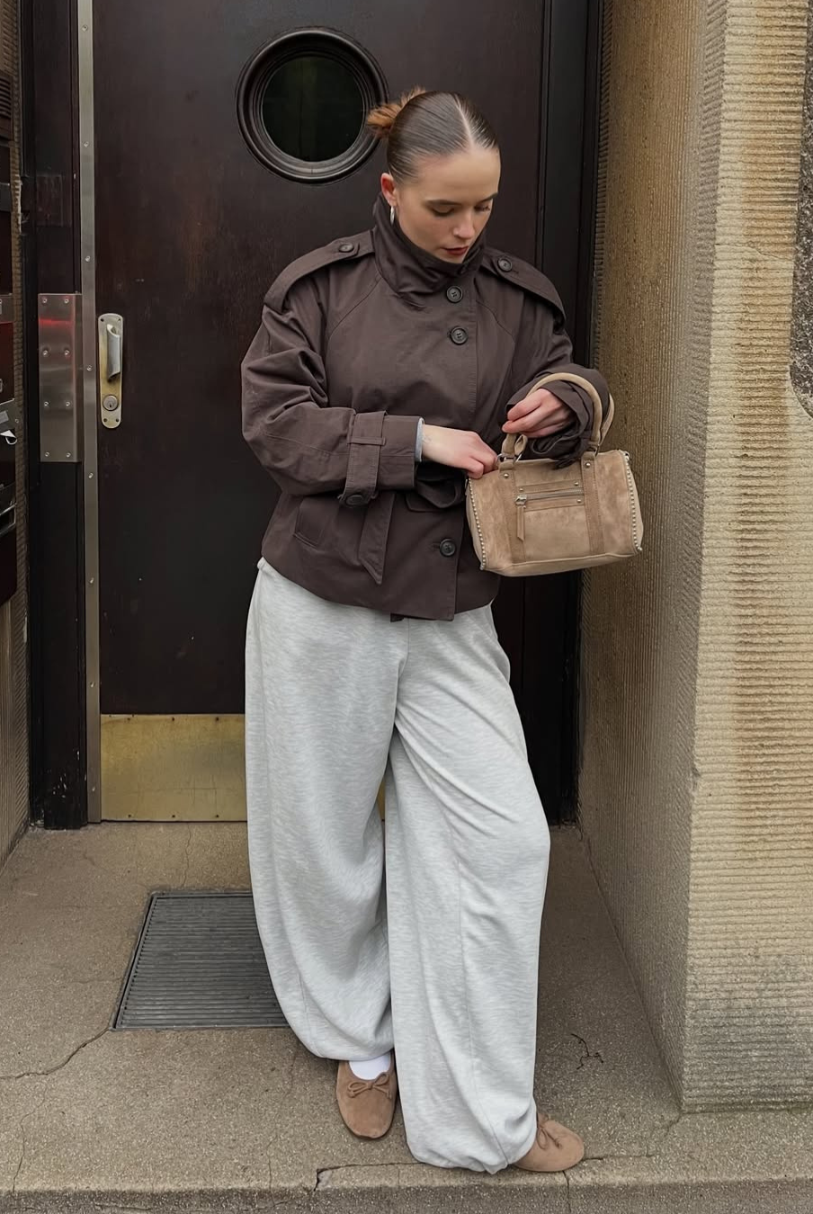 Brown short trench coat, model looking down, front view