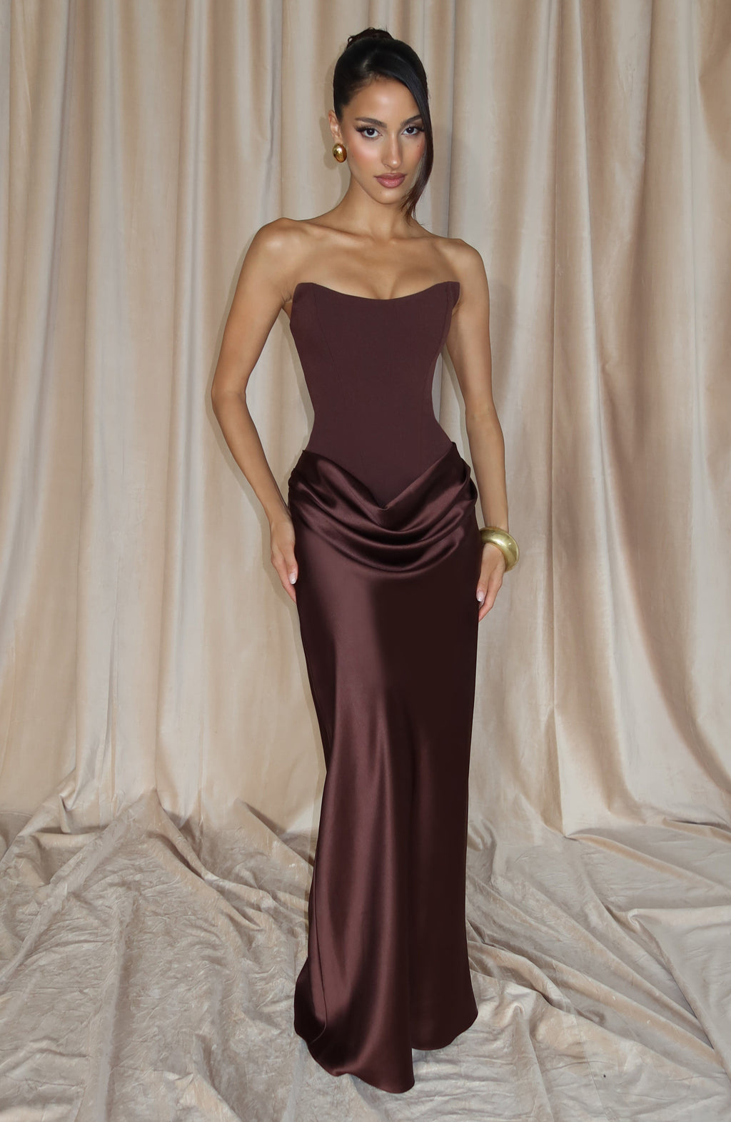 Chocolate brown strapless satin maxi dress, lifestyle shot against curtain