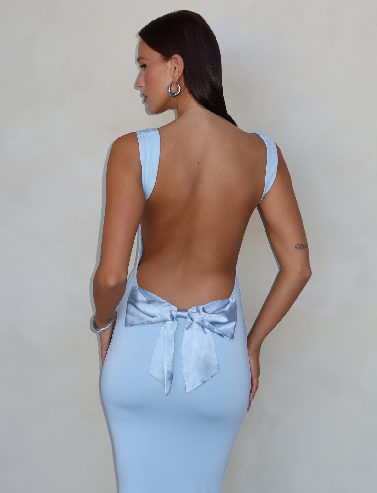 Baby blue maxi dress with open back and bow, back view on model