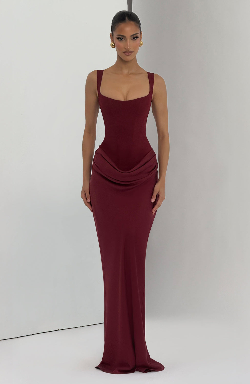 Burgundy corset-style maxi dress on model, full length studio