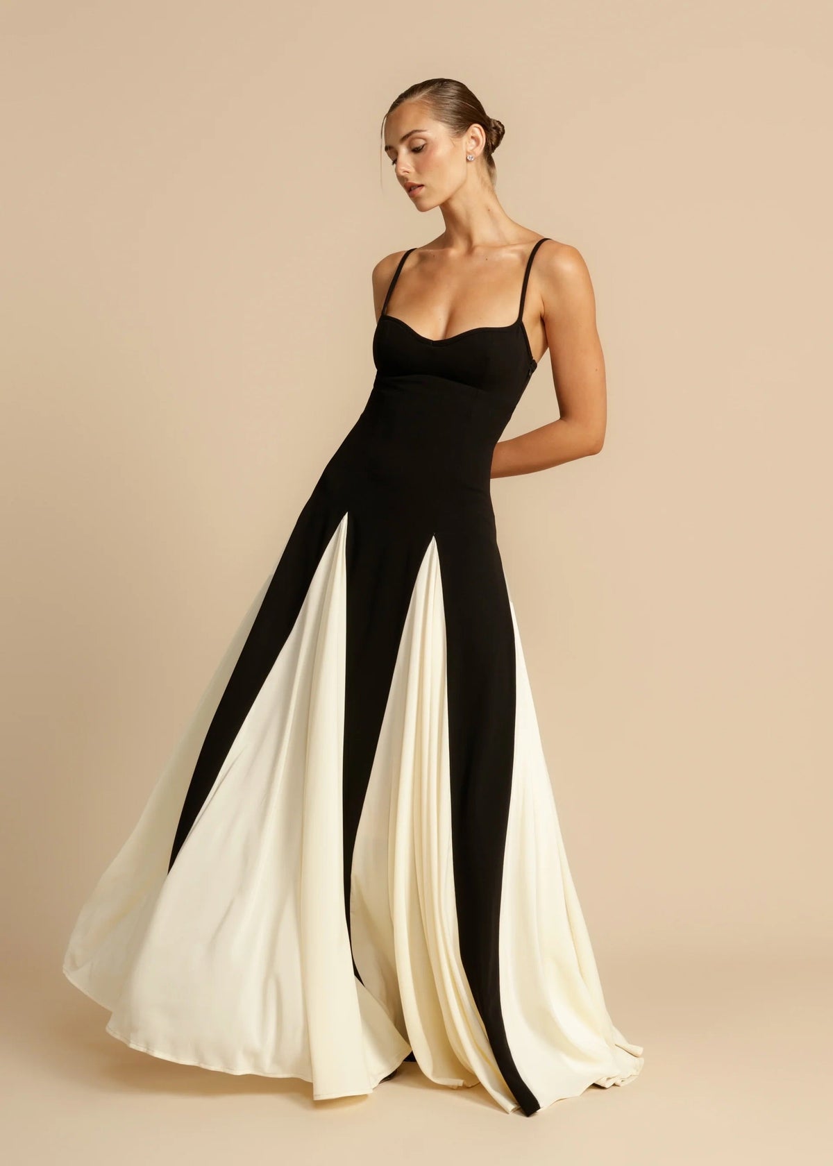 Black maxi dress with ivory godets, three-quarter view on model