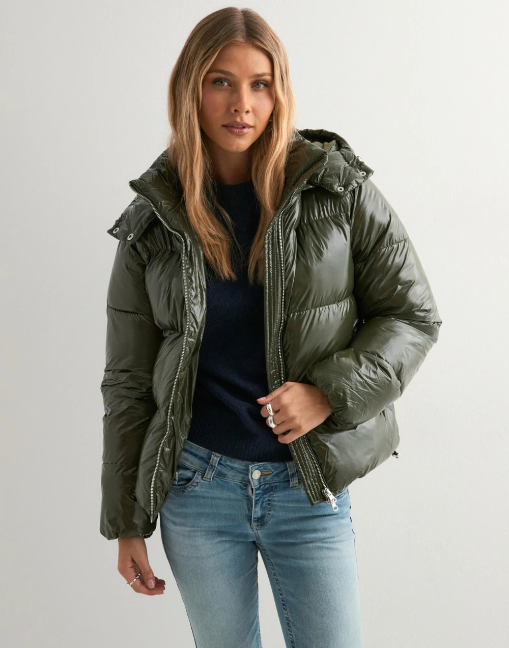 Green glossy hooded puffer jacket, front view unzipped on model