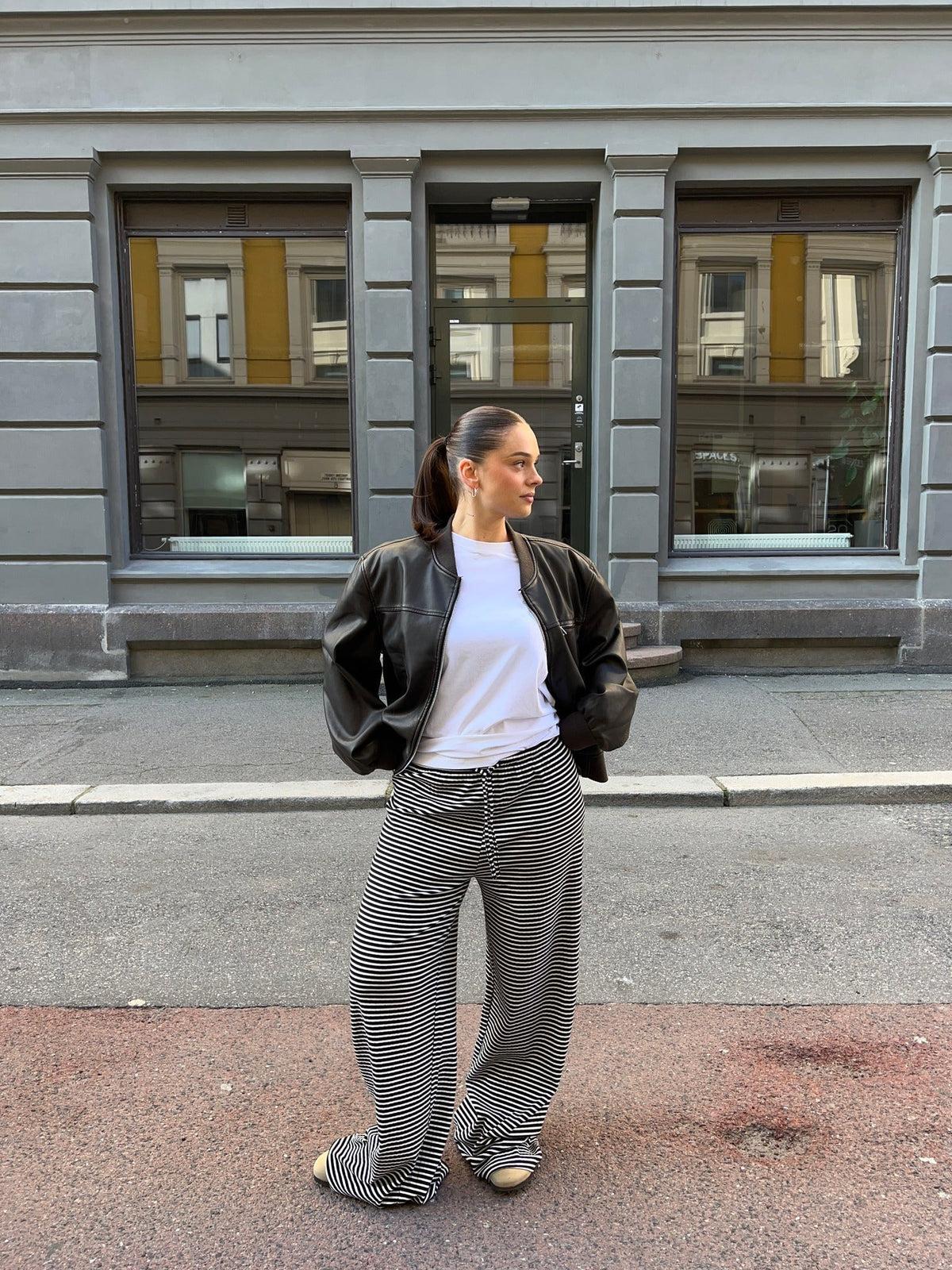 Black and white striped wide-leg trousers, street style on model