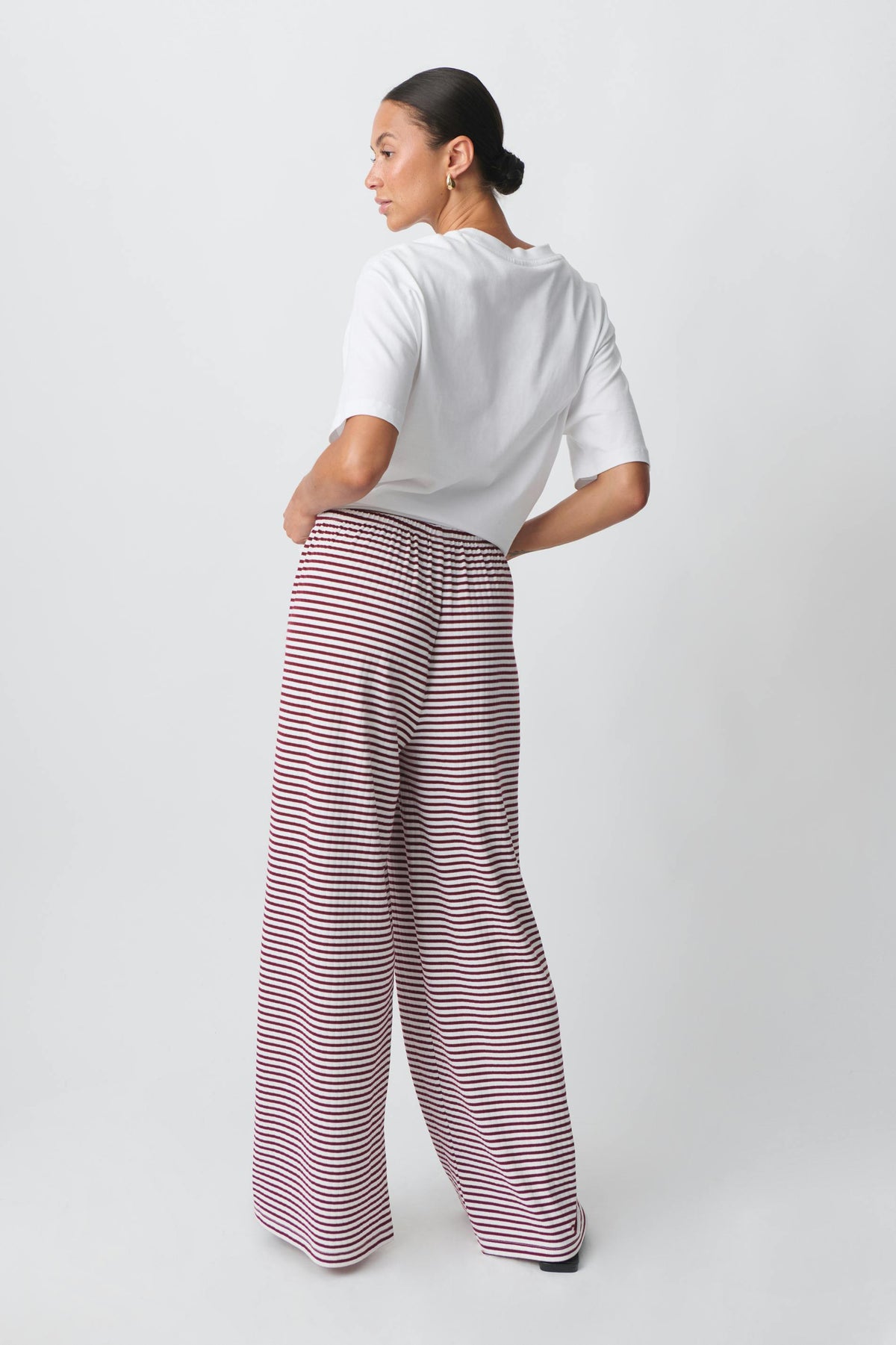 Red and white striped wide-leg trousers, back view on model