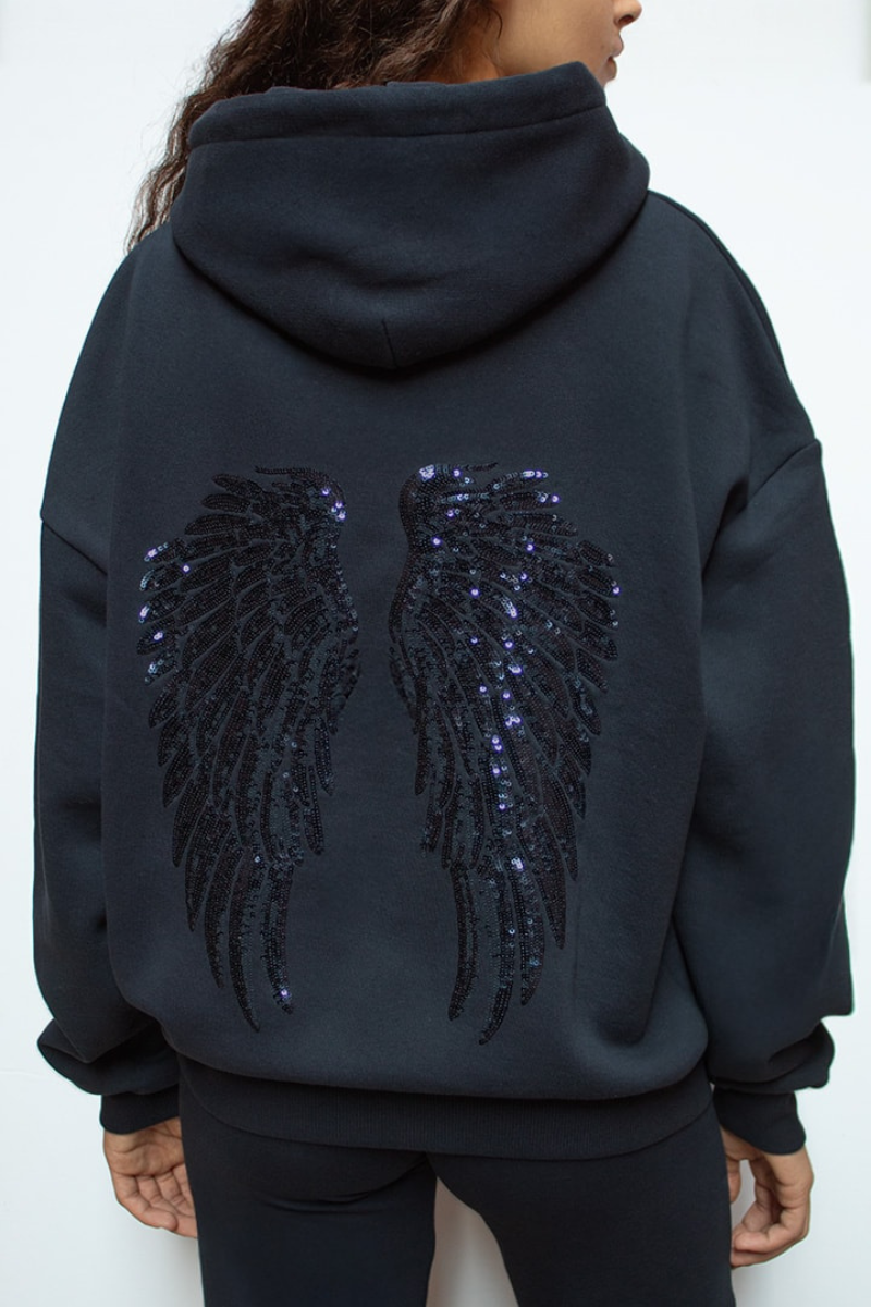 Detail of sequin angel wings on back of navy hoodie