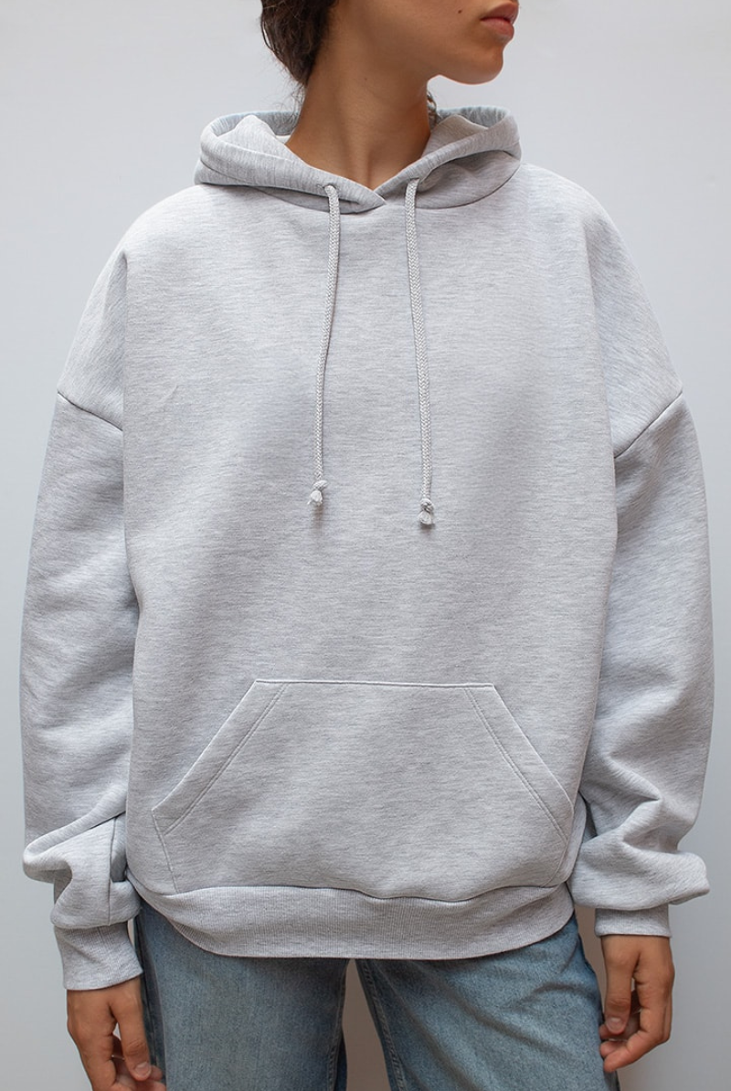 Close-up of grey hoodie front, hood and kangaroo pocket on model