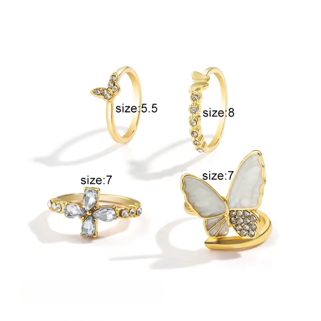 Gold butterfly ring set, four rings with size labels on white background