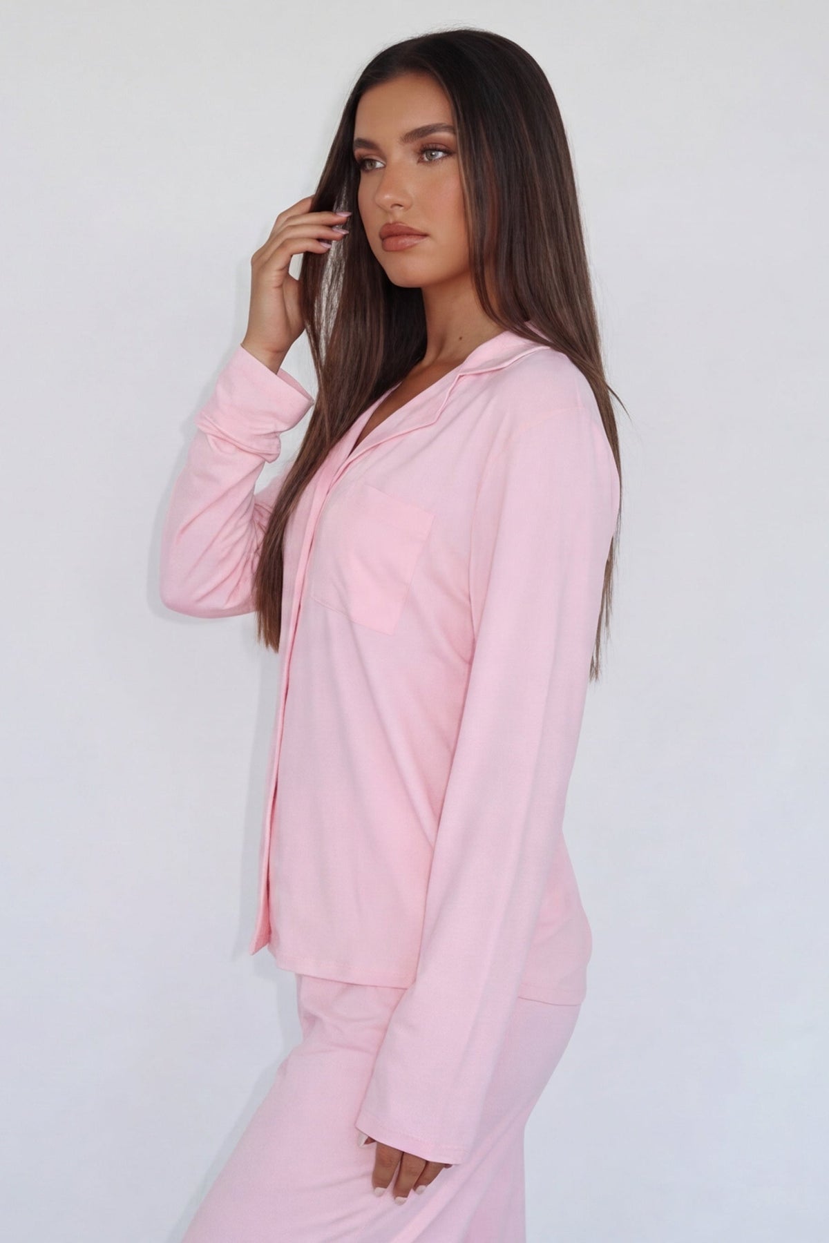 Close-up of pink pyjama shirt with chest pocket, side view on model
