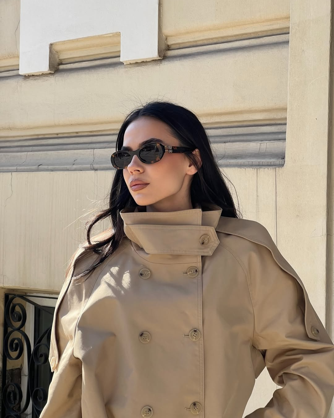 Close-up of camel trench coat collar and buttons on model