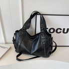 Midnight black leather shoulder bag, detail of the zip pockets
