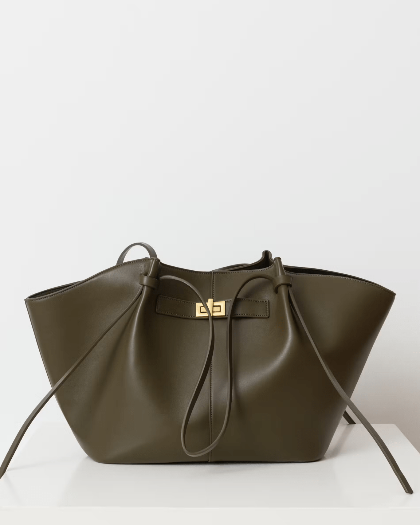 Olive green leather tote bag with twist-lock strap detail, front view