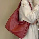 Deep wine leather slouchy shoulder bag worn on model, close-up