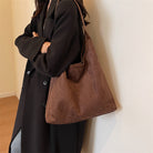 Model wearing the coffee brown suede tote bag over her shoulder