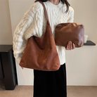 Model carrying the maroon suede shoulder tote bag on her arm