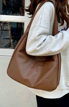 Mocha brown leather slouchy shoulder bag worn on model, close-up