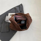 Interior of the coffee brown suede tote bag with items inside