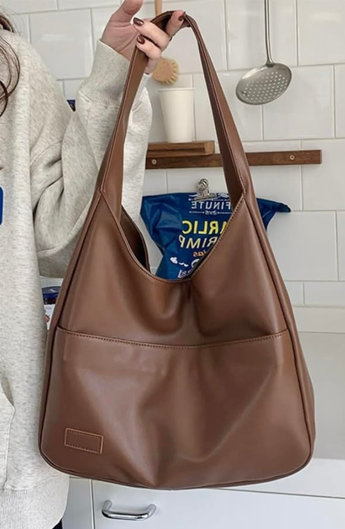 Mocha brown leather slouchy shoulder bag held on model's arm