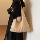 Model wearing the beige suede tote bag over her shoulder