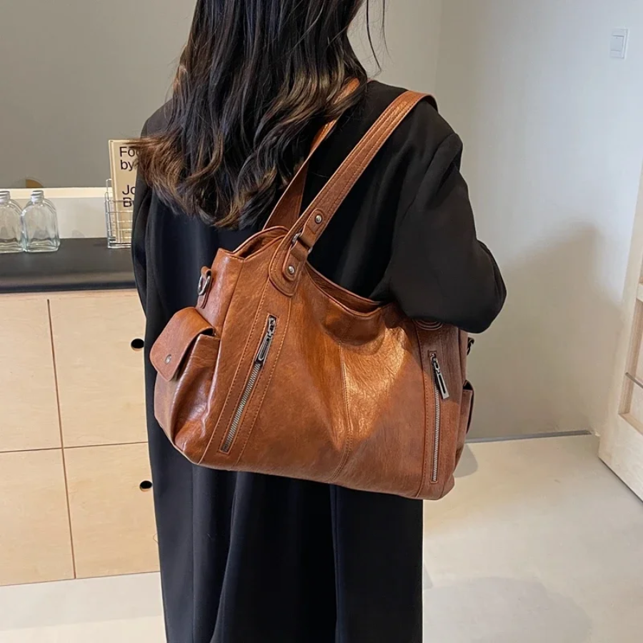 Cognac tan leather shoulder bag worn on shoulder, back view