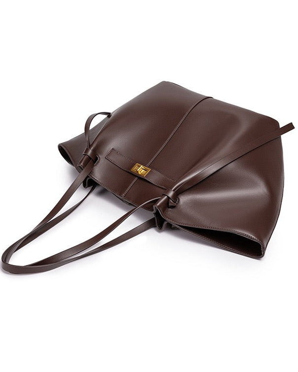 Dark brown leather tote bag lying flat, showing straps and clasp