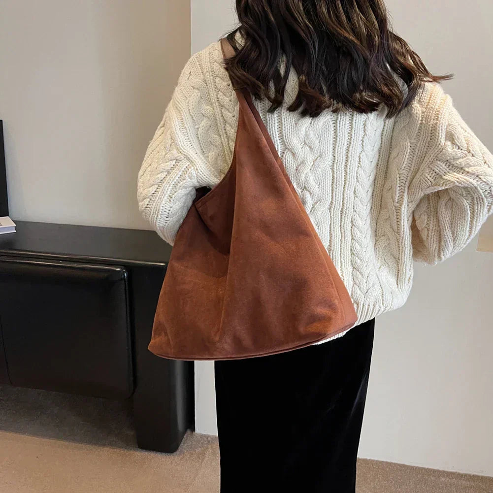 Model wearing the maroon suede tote bag over her shoulder, back view