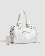 White vintage-style weave bag with braided trim, angled front view