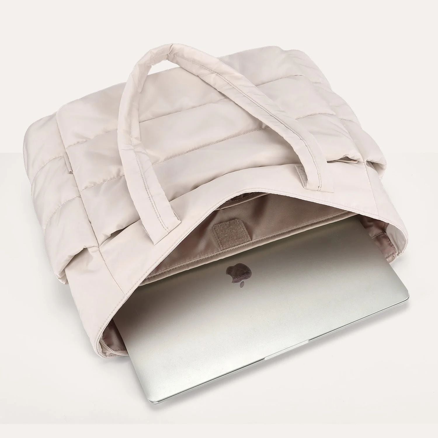 Beige puffer tote bag flat lay with a laptop inside