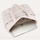 Beige puffer tote bag flat lay with a laptop inside