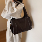 Espresso brown leather shoulder bag worn on model, close-up