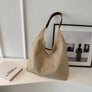 Beige suede shoulder tote bag on a desk
