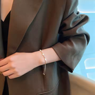 Gold bracelet with opal charms worn on wrist, close-up lifestyle shot