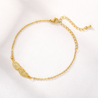Gold angel wing bracelet, flat lay close-up