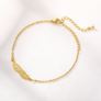 Gold angel wing bracelet, flat lay close-up