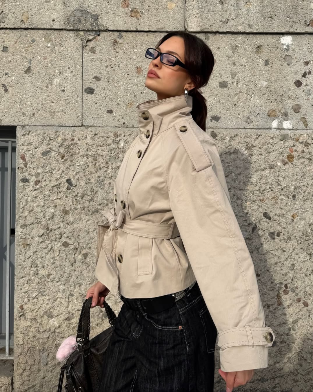 Sand short trench coat with high collar and belt, side view on model