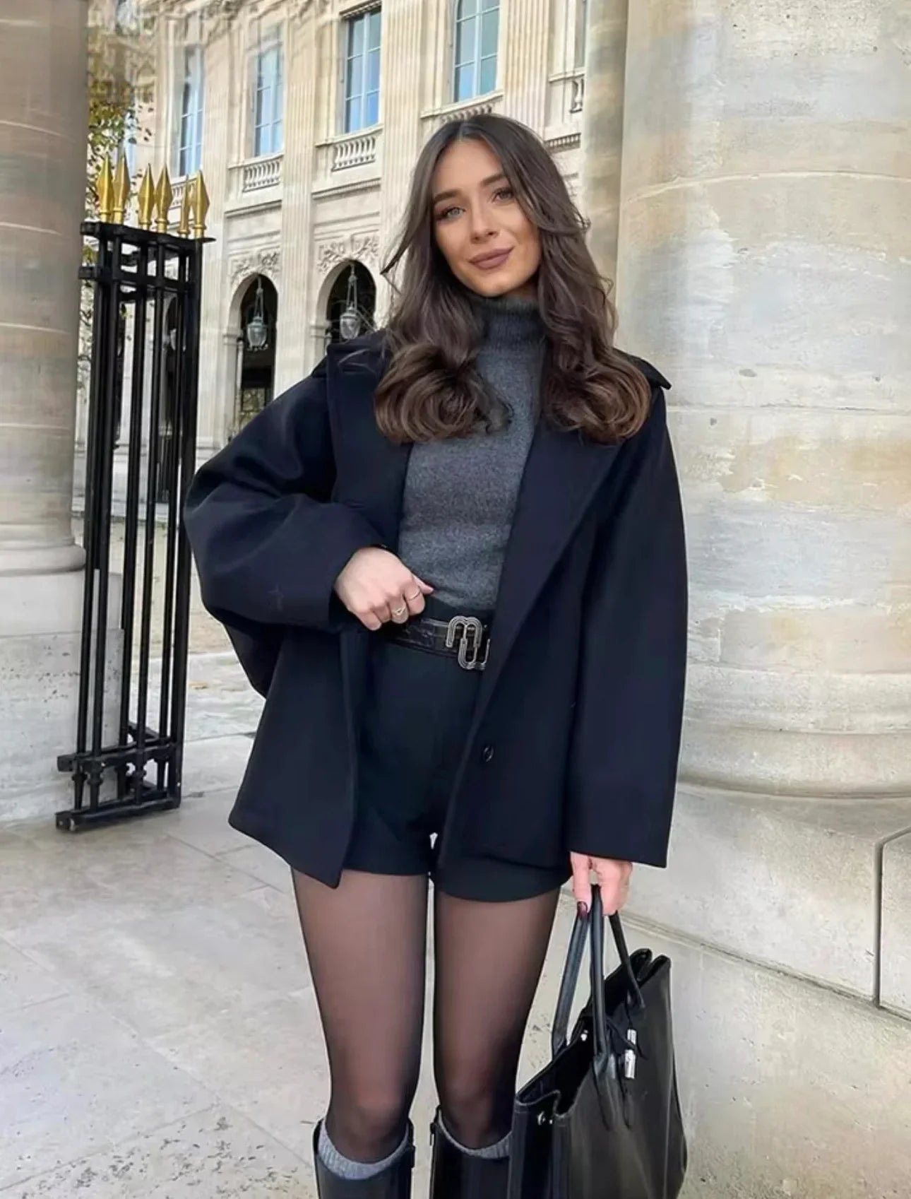 Black oversized coat over grey jumper and shorts, front view