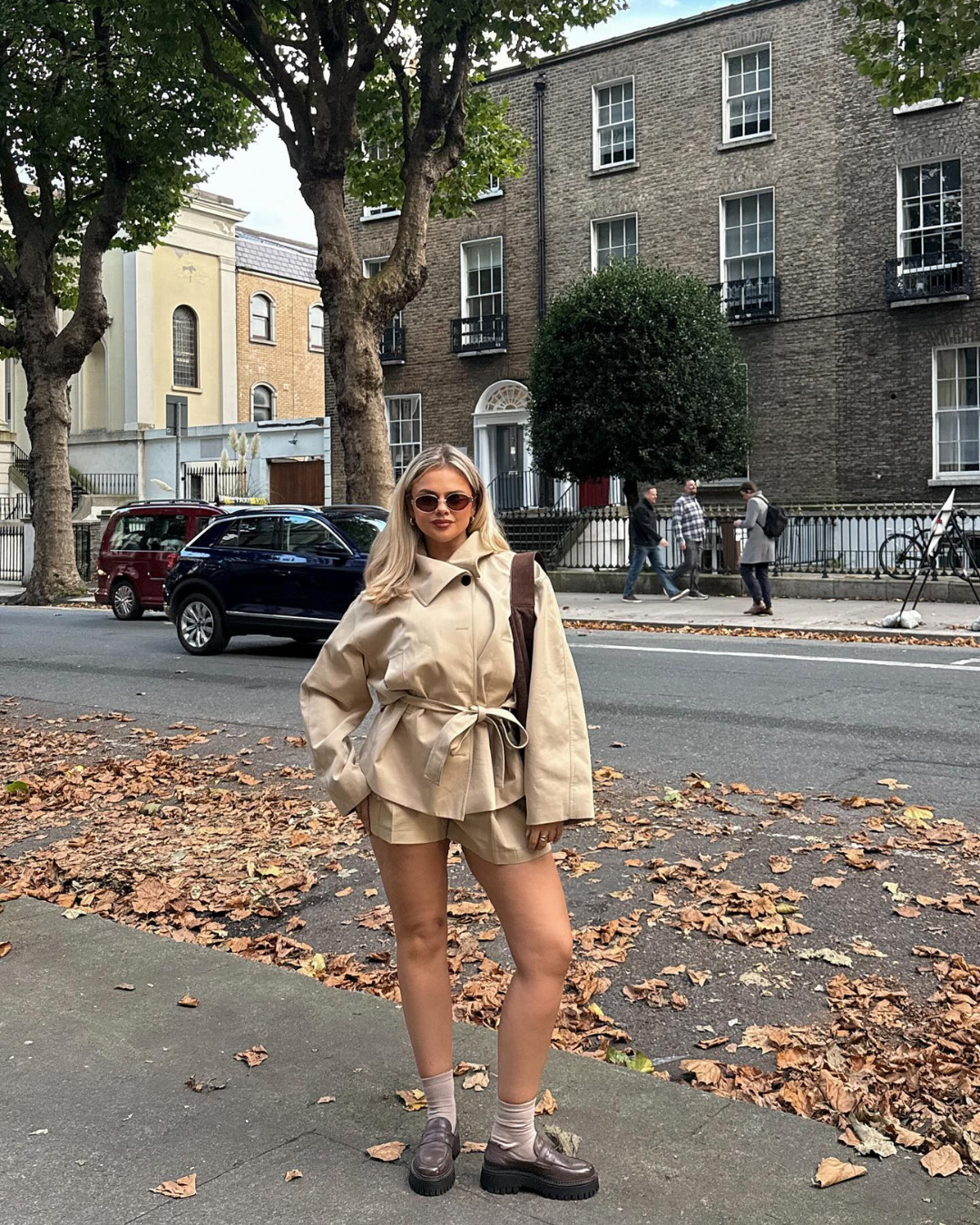 Beige belted trench jacket and shorts set, model on city street