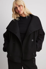 Black double-breasted cropped coat, front view on model