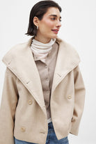 Close-up of light beige double-breasted coat on model