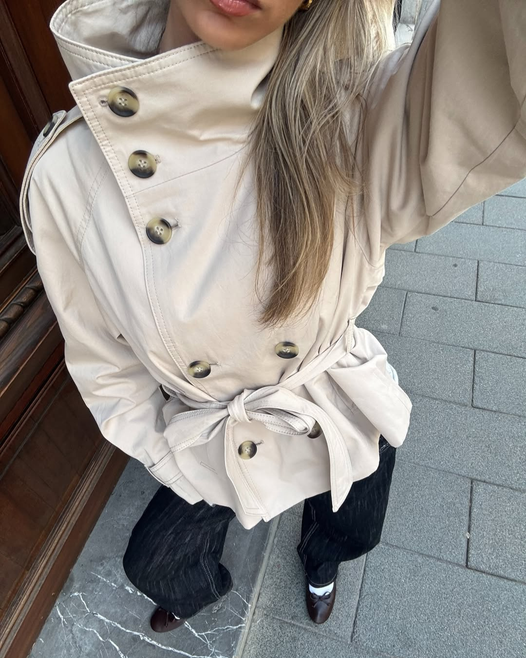 Close-up of sand trench coat double-breasted buttons and belt