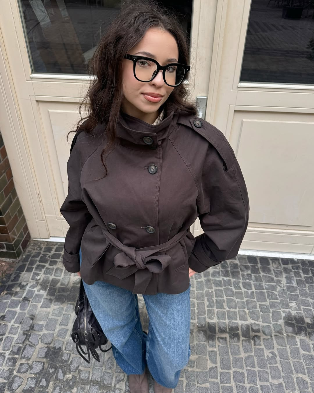 Brown short trench coat with funnel collar, close front view on model