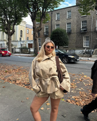 Close-up of beige belted trench jacket and shorts set on model
