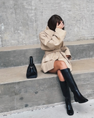 Beige trench jacket and shorts set, model sitting on concrete steps