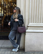 Charcoal short cape, model leaning against pillar, side view