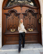 Sand short trench coat, model glancing back, three-quarter view